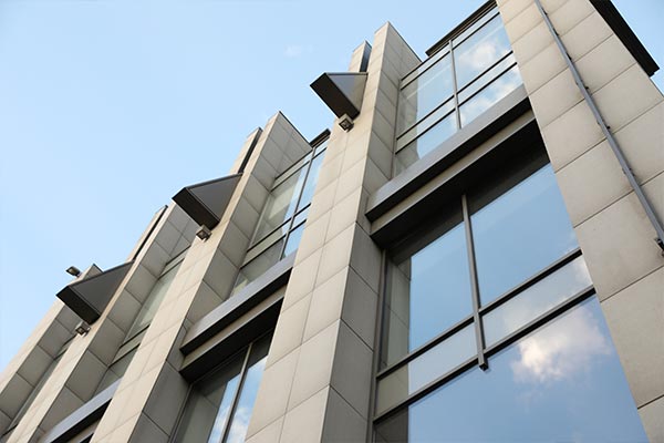 Looking up at a building from the outside with glass windows